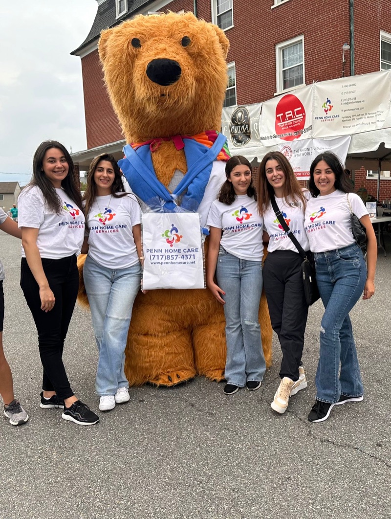 Penn Home Care team with the bear mascot at a street festival