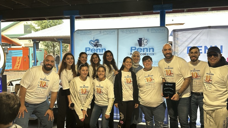 Penn team members in matching shirts at a community event booth